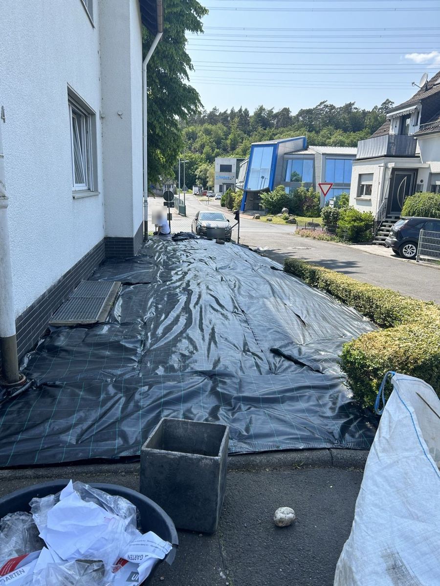 Vorher: Fläche am Haus mit Unkrautvlies abgedeckt